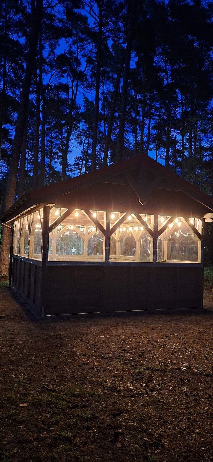Widok oświetlonej wiaty grillowej nocą